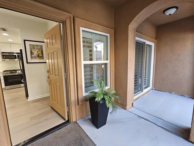 a view of a hallway with wooden floor and a potted plant