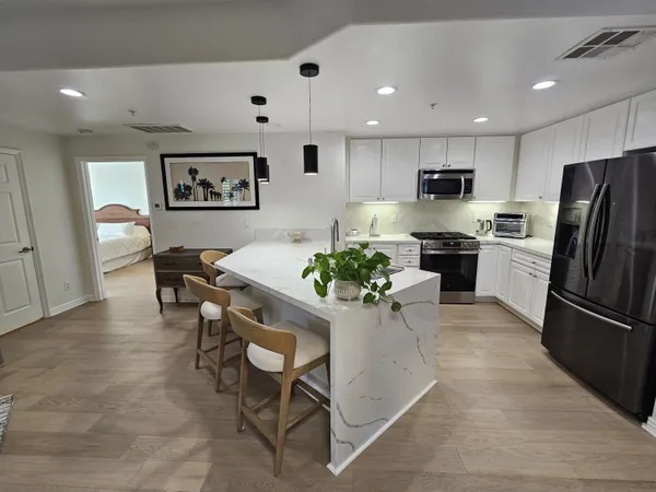 a kitchen with stainless steel appliances kitchen island granite countertop a refrigerator and a stove top oven