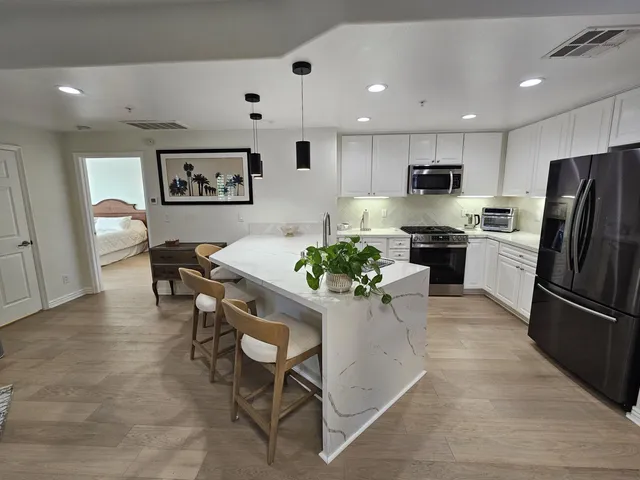 a kitchen with stainless steel appliances kitchen island granite countertop a refrigerator and a stove top oven