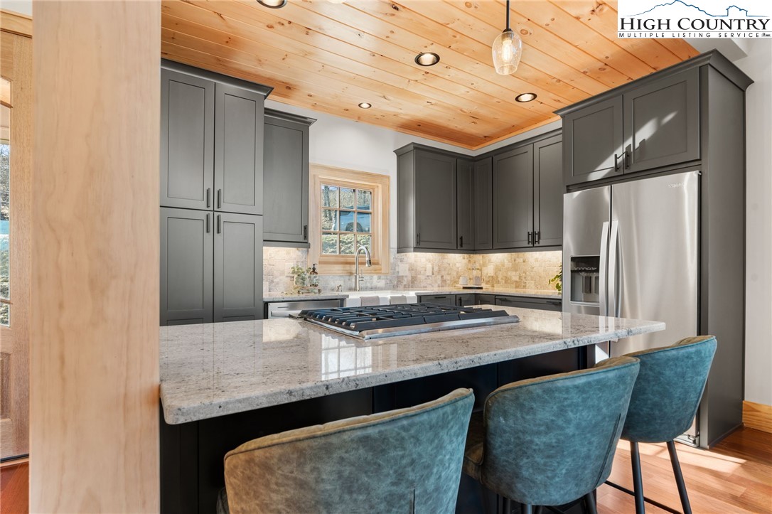 171 Pleasant View Vilas, NC 28692 - Photo 12 of 49 a kitchen with stainless steel appliances granite countertop a table chairs in it and wooden floors
