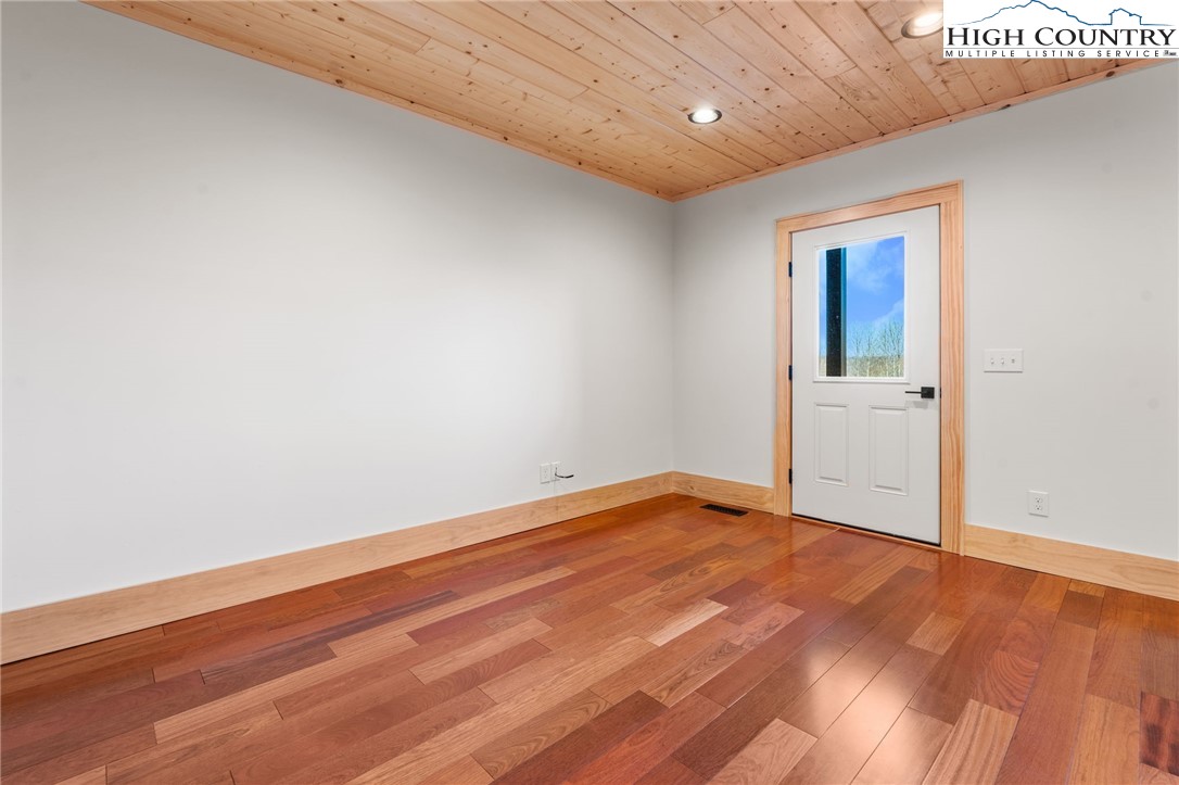 171 Pleasant View Vilas, NC 28692 - Photo 37 of 49 an empty room with wooden floor and windows