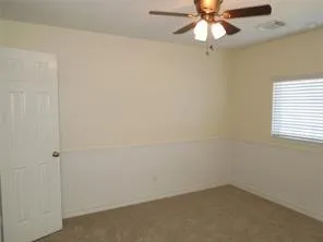 an empty room with a window and a fan