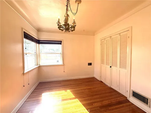 a view of a room with wooden floor and chandelier
