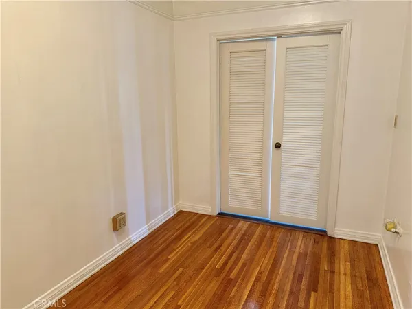 a view of a room with wooden floor and white walls