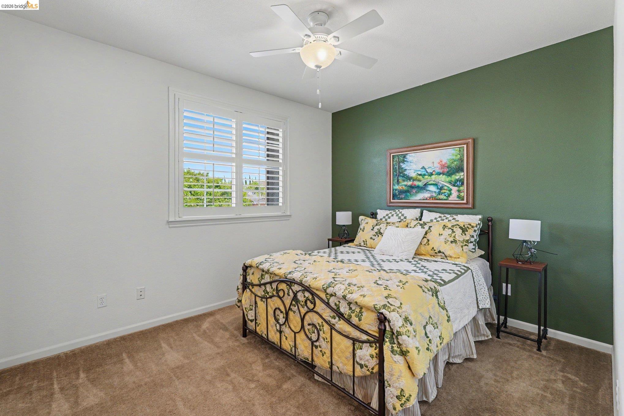 106 Little Ranch Circle Oakley, CA 94561 - Photo 20 of 34 Interior room featuring a white ceiling fan with integrated lighting, a window with plantation shutters, a green accent wall, white wall trim, and wall-to-wall carpeting