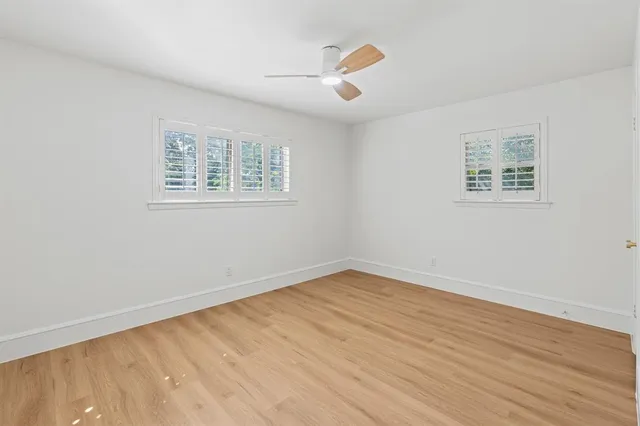 an empty room with wooden floor and window