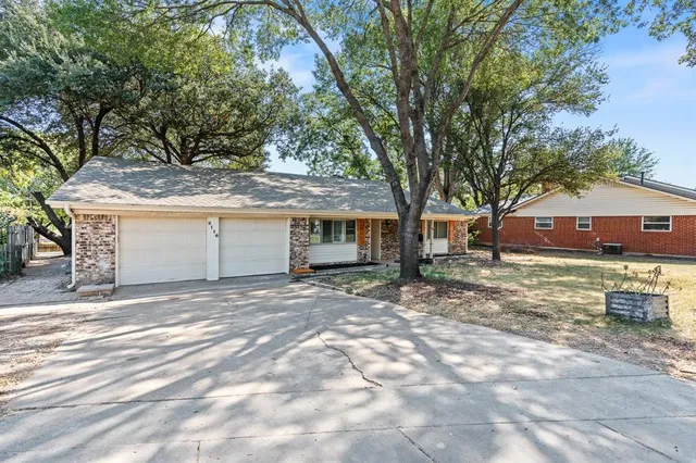 a view of house with outdoor space and trees in the background