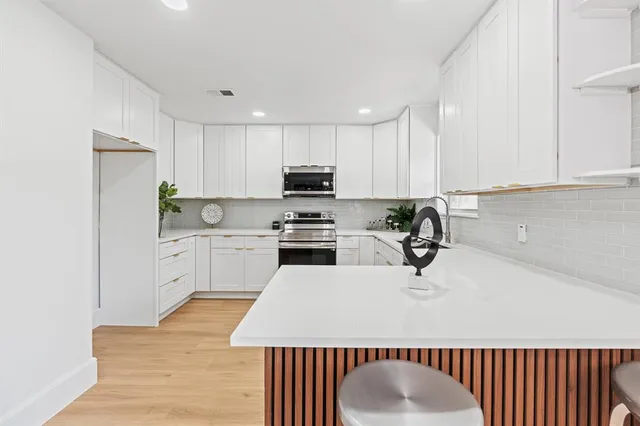 a kitchen with a sink a white cabinets and a stainless steel appliances