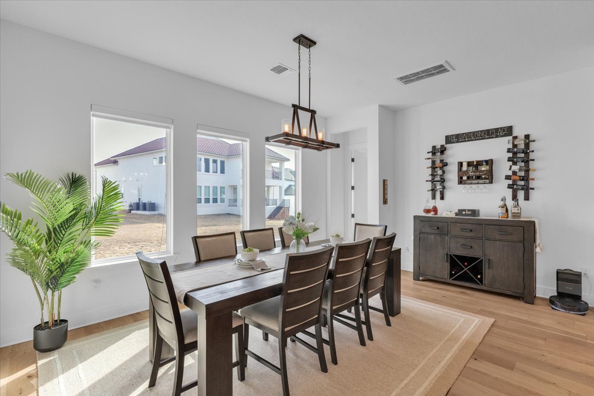 2312 Mondello Path Leander, TX 78641 - Photo 25 of 40 a dining room with furniture potted plants and wooden floor