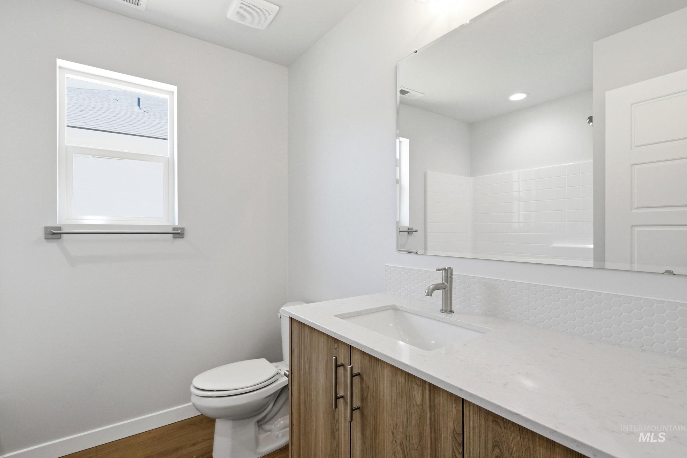 1184 West Jasper Street Meridian, ID 83642 - Photo 12 of 18 Bathroom vanity featuring a wood-finish cabinet, white countertop, and integrated sink