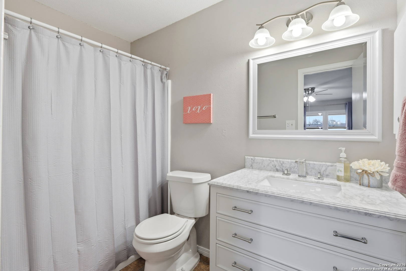 9140 Timber Path, Unit 3003 San Antonio, TX 78250 - Photo 24 of 38 a bathroom with a granite countertop toilet a sink a mirror and a shower curtain