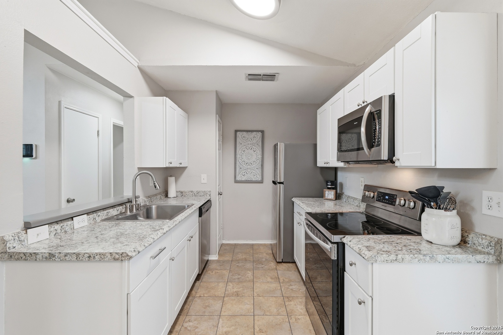 9140 Timber Path, Unit 3003 San Antonio, TX 78250 - Photo 4 of 38 a kitchen with granite countertop a sink stove and cabinets
