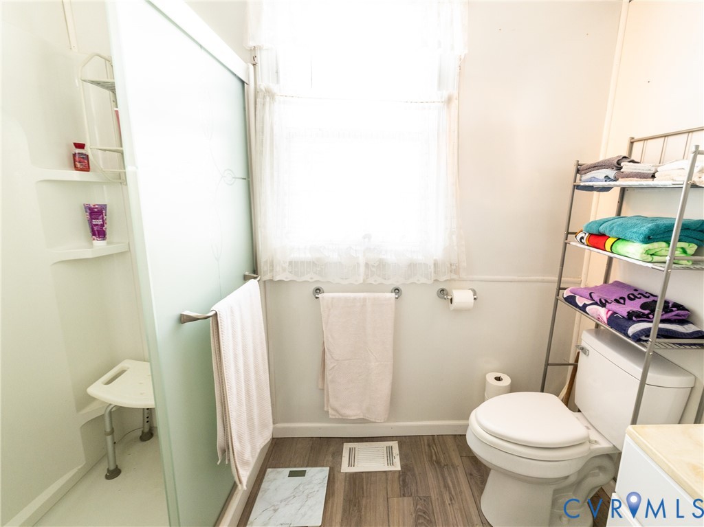 515 Ruthers Road Richmond, VA 23225 - Photo 21 of 34 a white toilet sitting next to a bathroom sink and a mirror