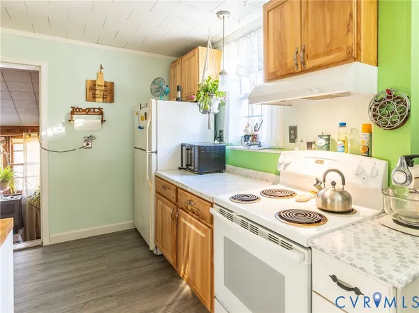 a kitchen with a refrigerator a stove and wooden floor
