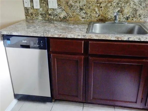 a view of kitchen island with granite countertop cabinets