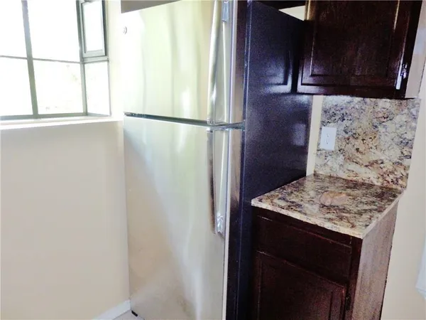 a view of a refrigerator in kitchen and wooden floor