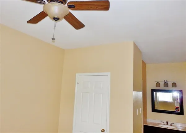 a view of hallway with a chandelier fan and wooden floor
