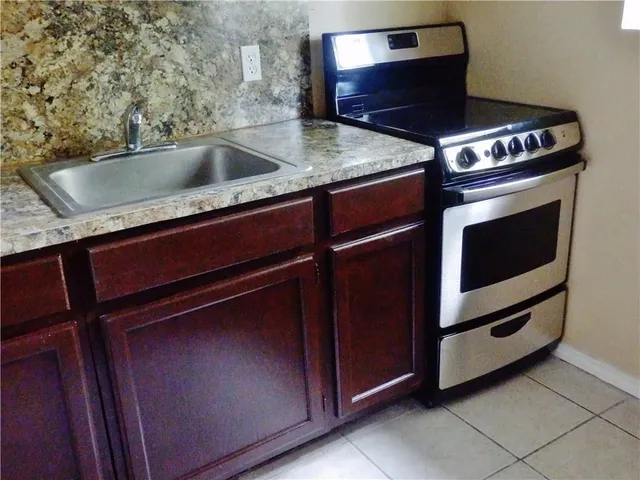 a kitchen with granite countertop a stove and a sink