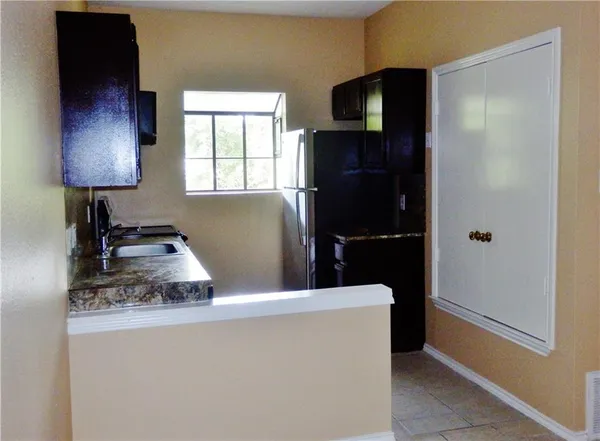 a kitchen with a refrigerator and a dresser