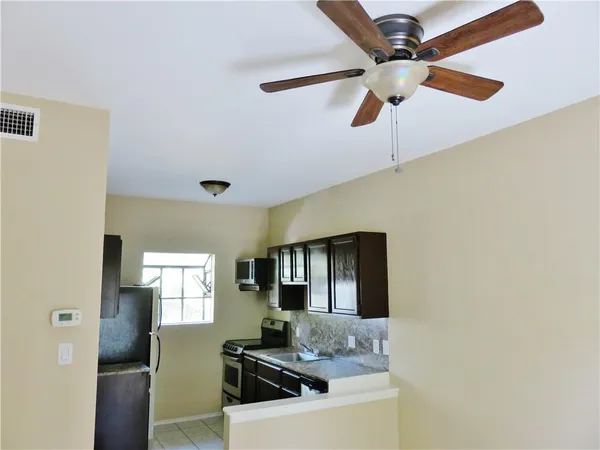 a kitchen with stainless steel appliances granite countertop a sink a stove and a refrigerator