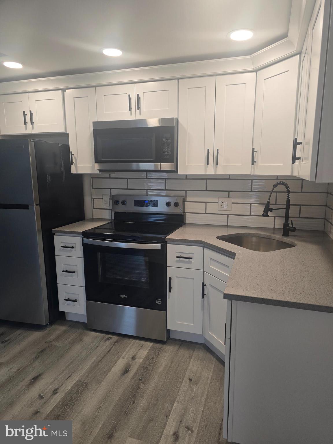 5925 Ridge Avenue, Unit 4 Philadelphia, PA 19128 - Photo 13 of 15 a kitchen with a sink and a stove top oven