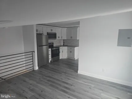 a kitchen with wooden floors and appliances