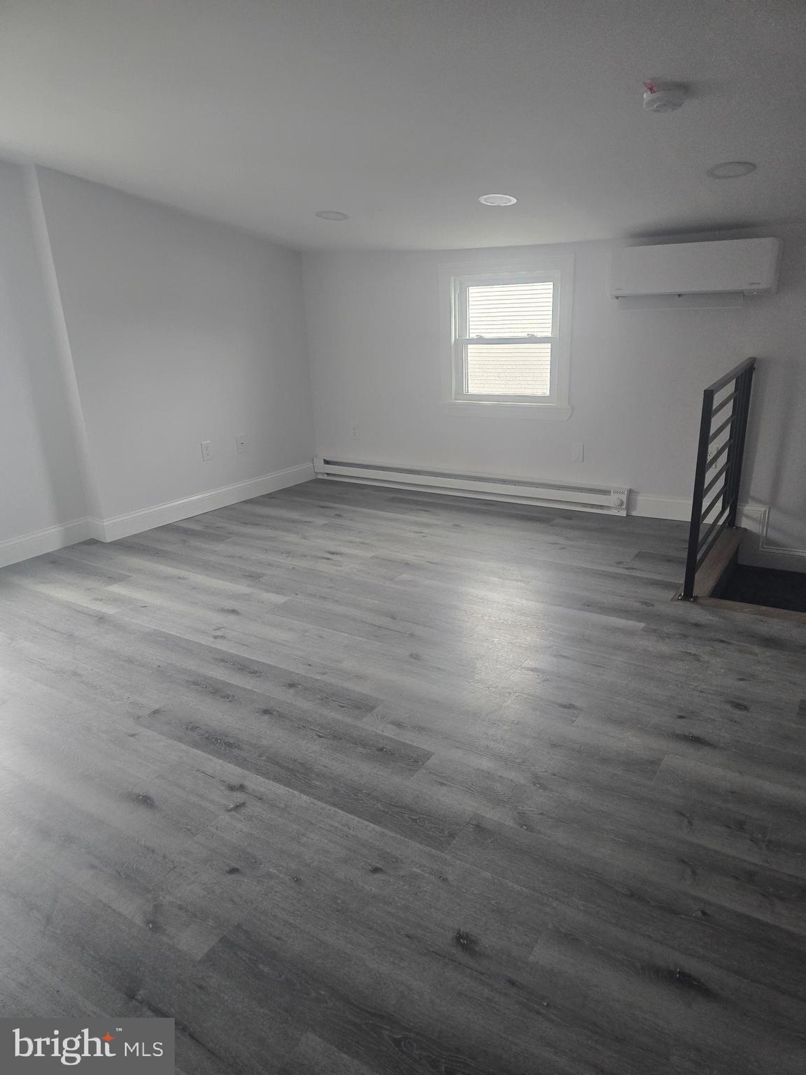 5925 Ridge Avenue, Unit 4 Philadelphia, PA 19128 - Photo 7 of 15 an empty room with wooden floor and windows