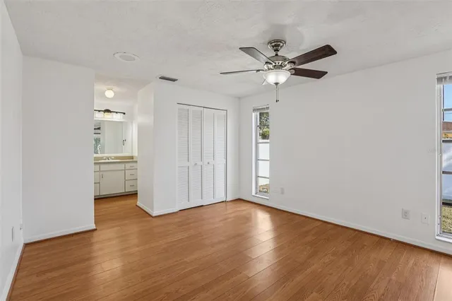 a view of an empty room with a window and wooden floor