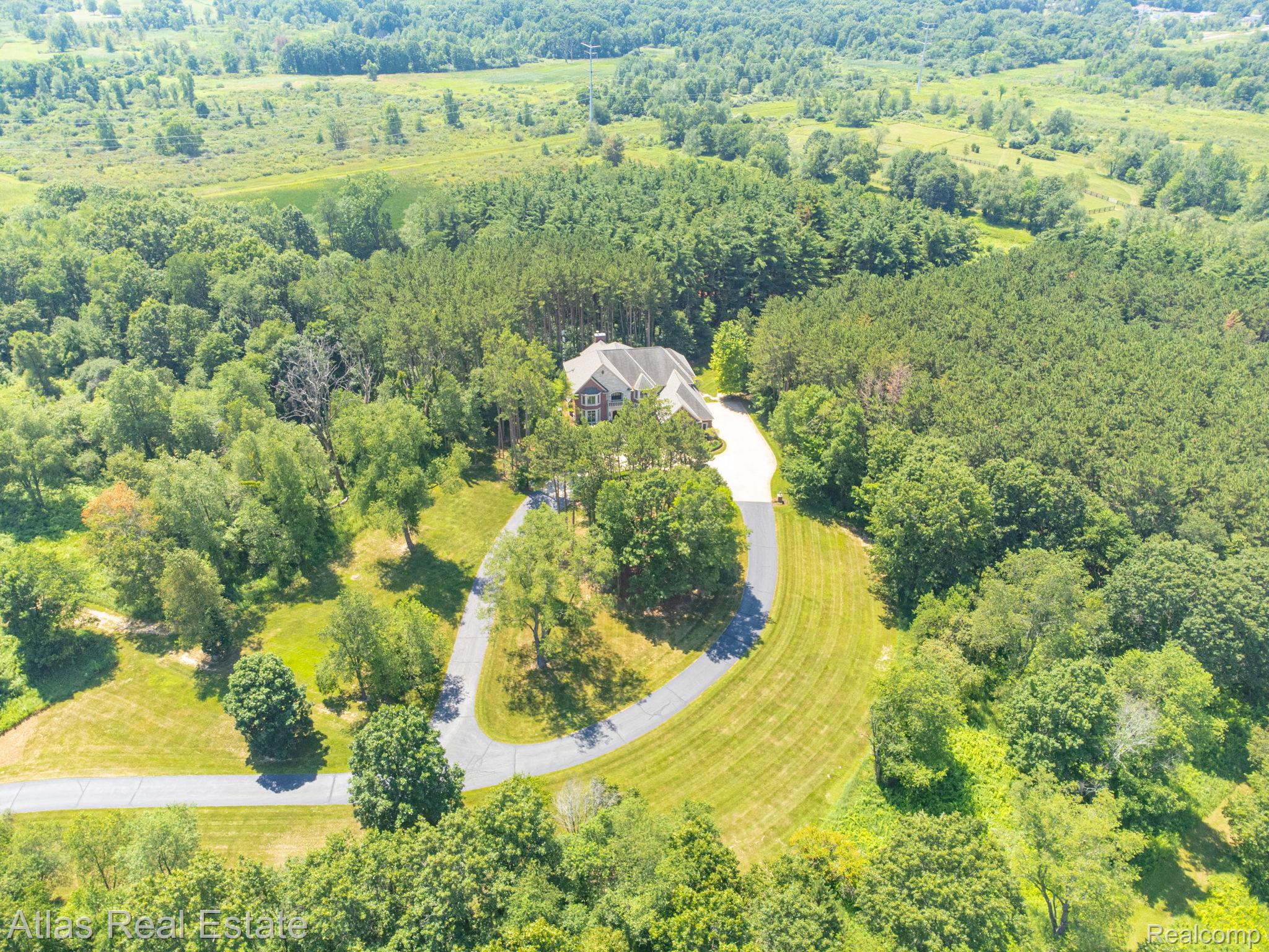10380 South State Road Goodrich, MI 48438 - Photo 19 of 87 Spacious property featuring a large residence nestled among extensive mature trees, surrounded by open fields and additional wooded areas