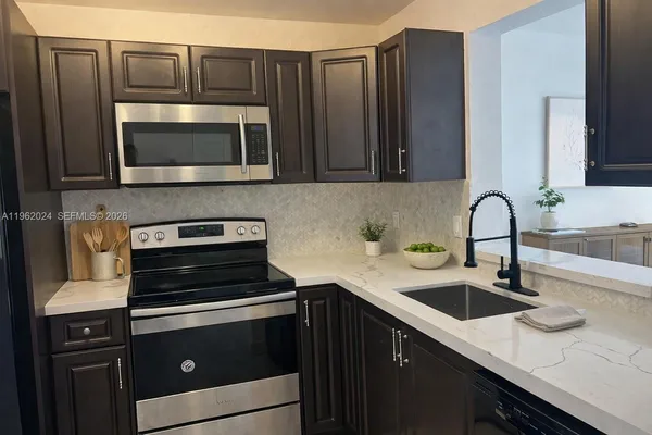 a kitchen with stainless steel appliances a stove sink and cabinets