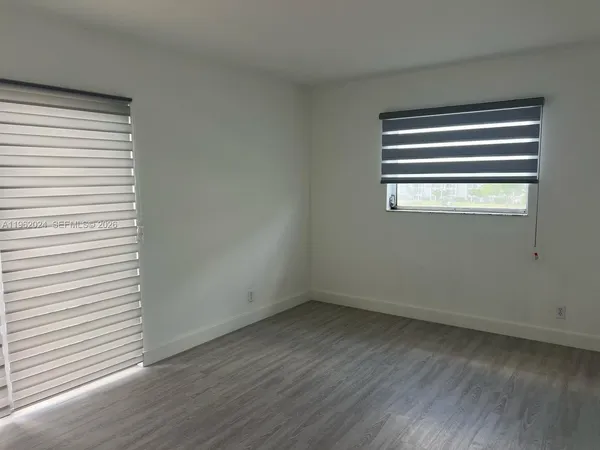 a view of a small space with wooden floor and a window