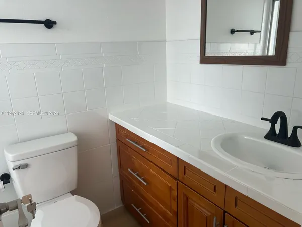 a bathroom with a sink a toilet and a mirror