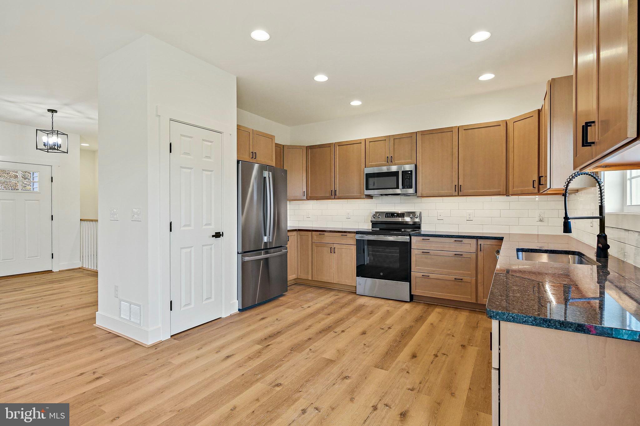335 East Snyder Corner Road Red Lion, PA 17356 - Photo 8 of 34 a kitchen with granite countertop a refrigerator and a stove top oven