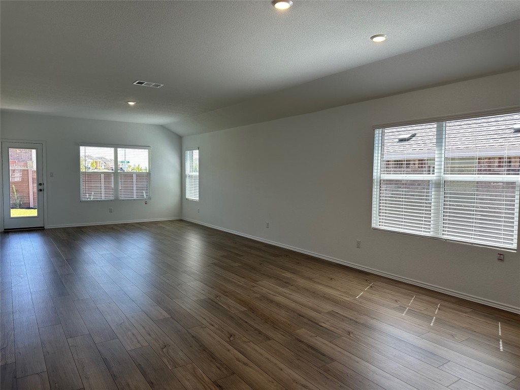 2513 Four Waters Loop Georgetown, TX 78628 - Photo 11 of 37 Spare room with wood finished floors, recessed lighting, and vaulted ceiling