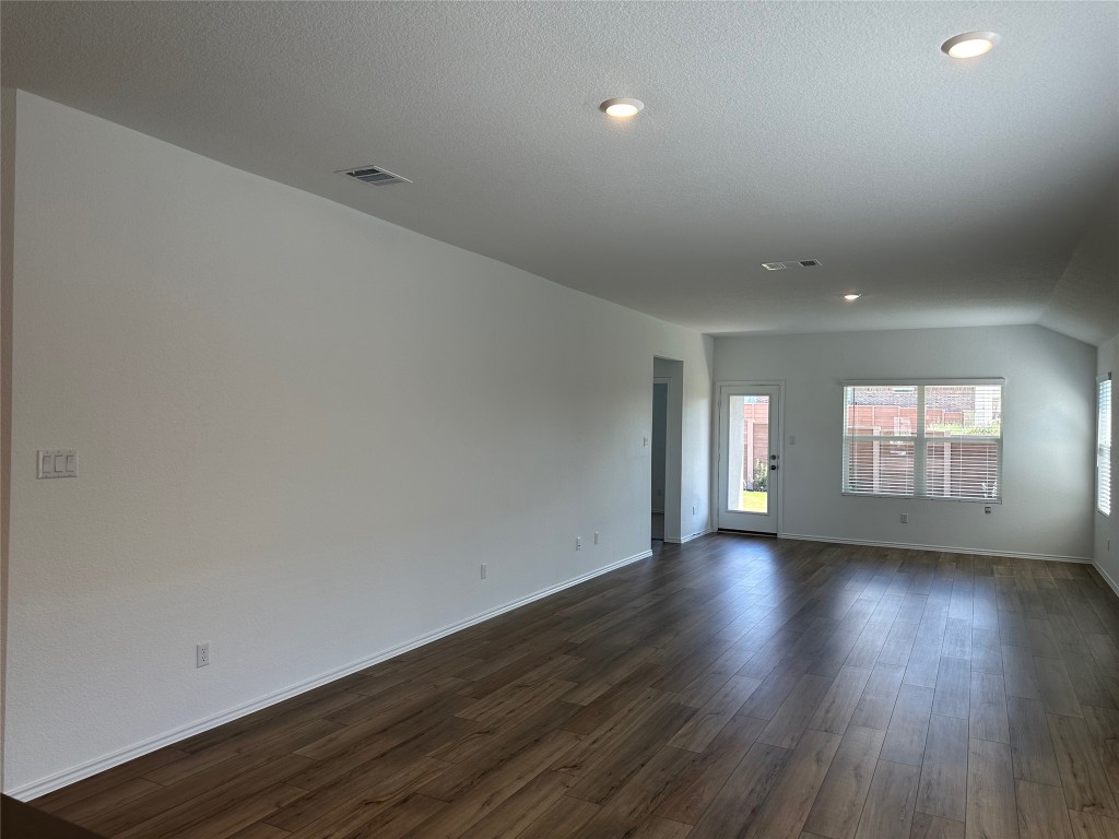 2513 Four Waters Loop Georgetown, TX 78628 - Photo 13 of 37 Unfurnished room featuring dark wood-style flooring, a textured ceiling, and recessed lighting