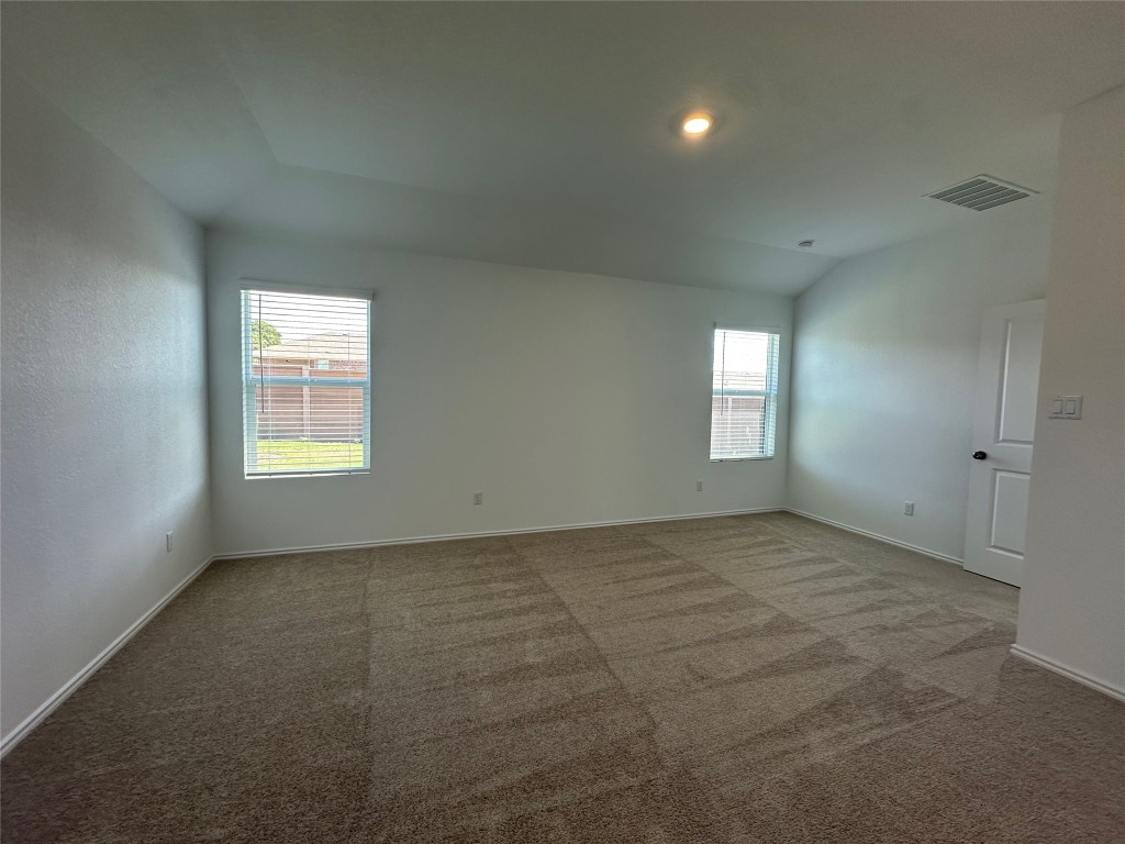2513 Four Waters Loop Georgetown, TX 78628 - Photo 14 of 37 Empty room with carpet floors and vaulted ceiling