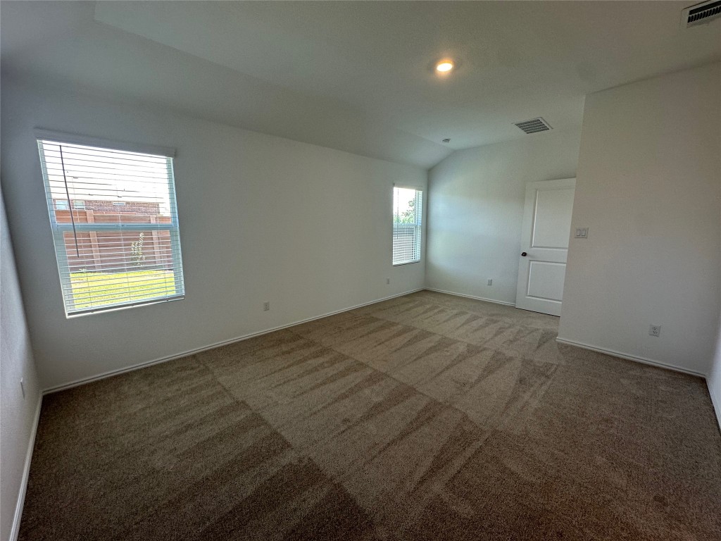 2513 Four Waters Loop Georgetown, TX 78628 - Photo 15 of 37 Carpeted spare room with vaulted ceiling and baseboards