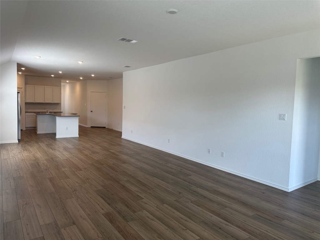 2513 Four Waters Loop Georgetown, TX 78628 - Photo 20 of 37 Unfurnished living room with dark wood finished floors and recessed lighting