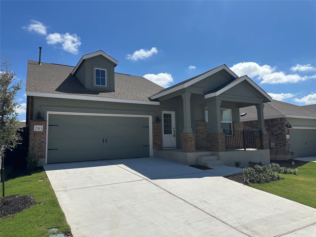 2513 Four Waters Loop Georgetown, TX 78628 - Photo 3 of 37 Craftsman-style house with brick siding, a porch, driveway, a garage, and roof with shingles