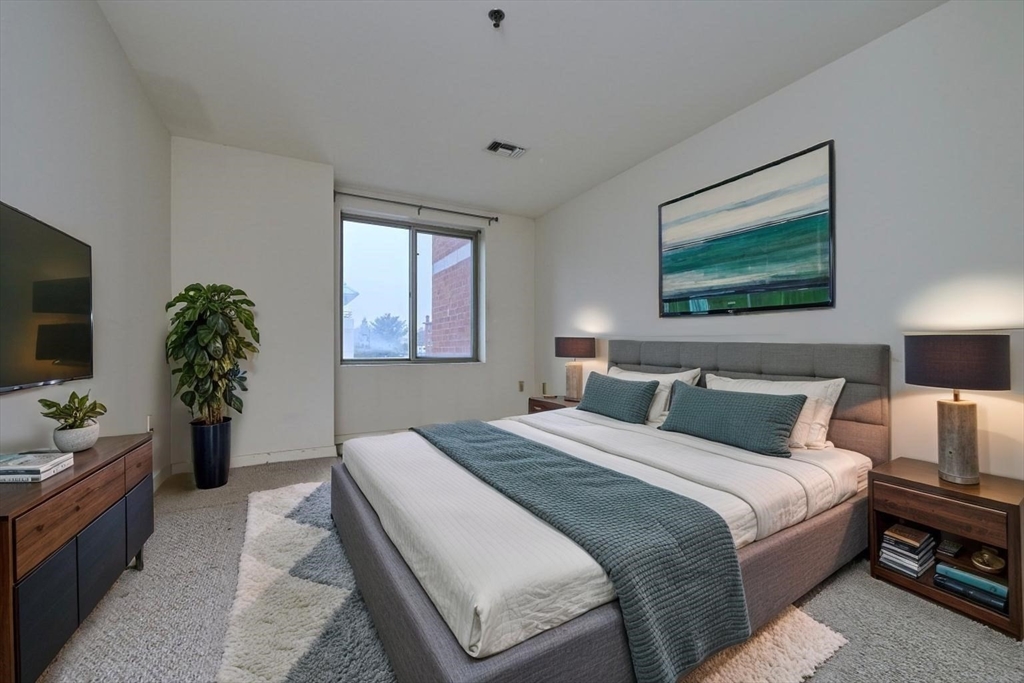 193 Oak Street, Unit 403 Newton, MA 02464 - Photo 4 of 21 a bedroom with a bed and a potted plant