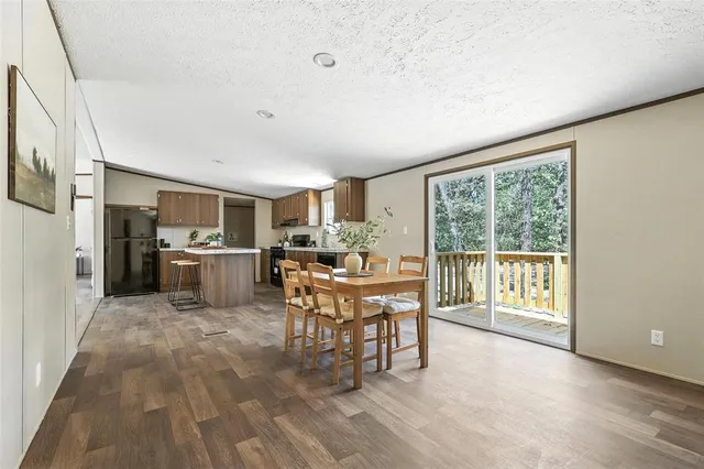 a work room with furniture a rug potted plant and windows