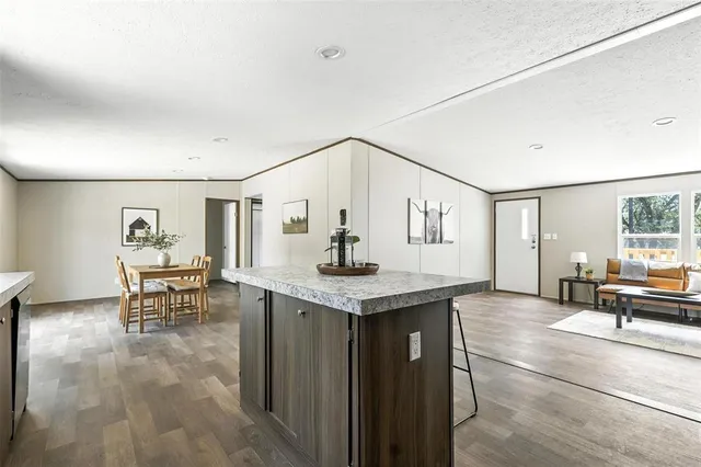a living room with furniture and view of kitchen