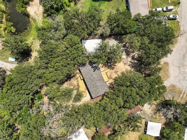 an aerial view of a house with a yard and lake view