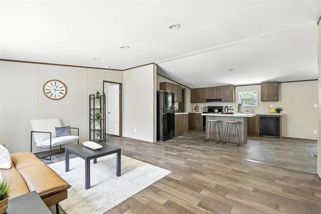 a living room with stainless steel appliances kitchen island granite countertop furniture and a kitchen view