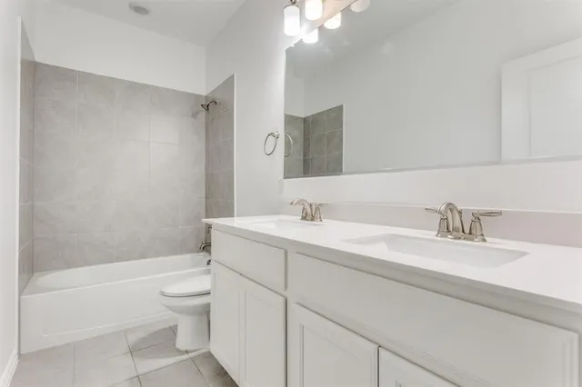 a bathroom with a granite countertop sink mirror vanity and toilet