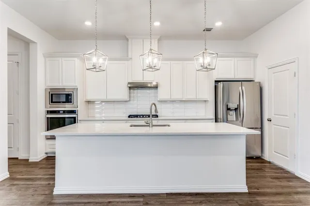 a large kitchen with kitchen island a sink stainless steel appliances and cabinets