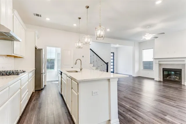a kitchen with granite countertop a sink and a stove top oven