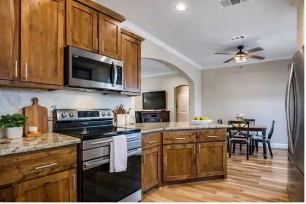 a kitchen with stainless steel appliances a stove sink microwave and cabinets