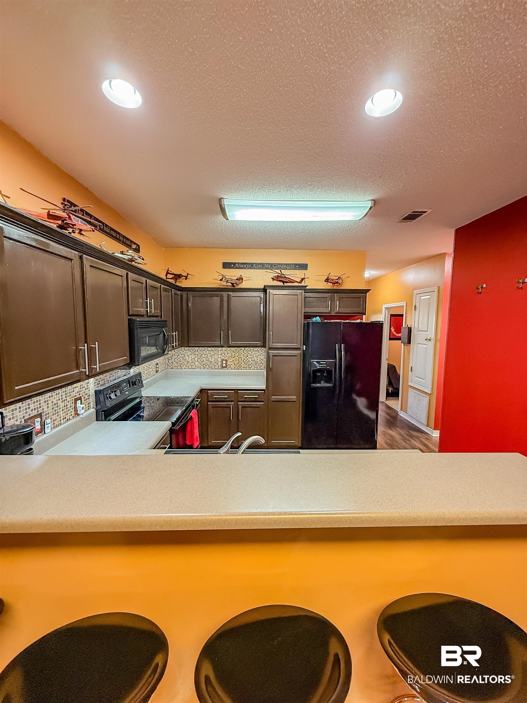 2651 South Juniper Street Foley, AL 36535 - Photo 3 of 20 Kitchen featuring black appliances, light countertops, dark brown cabinets, recessed lighting, and a breakfast bar