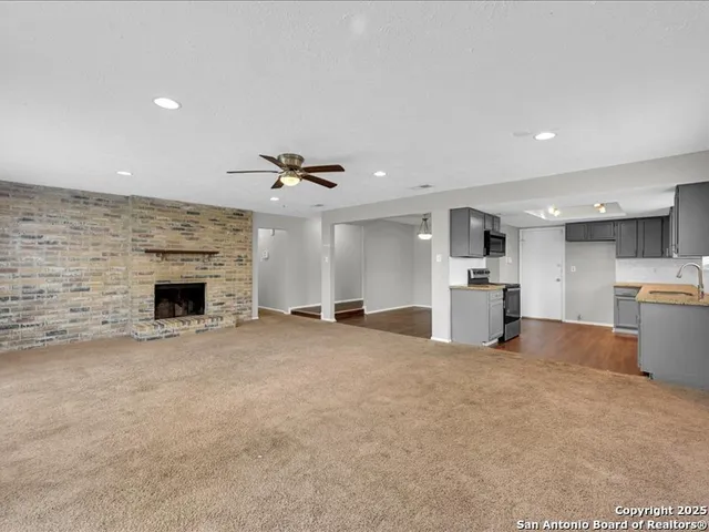 a view of a kitchen with a sink and a fireplace